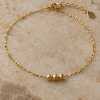 Fine gold-tone anklet with three small beads on pale stone