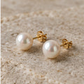 Freshwater pearl stud earrings on a light stone surface