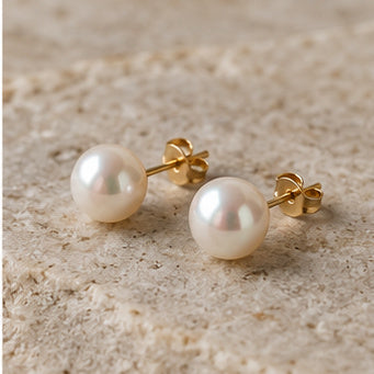 Freshwater pearl stud earrings on a light stone surface